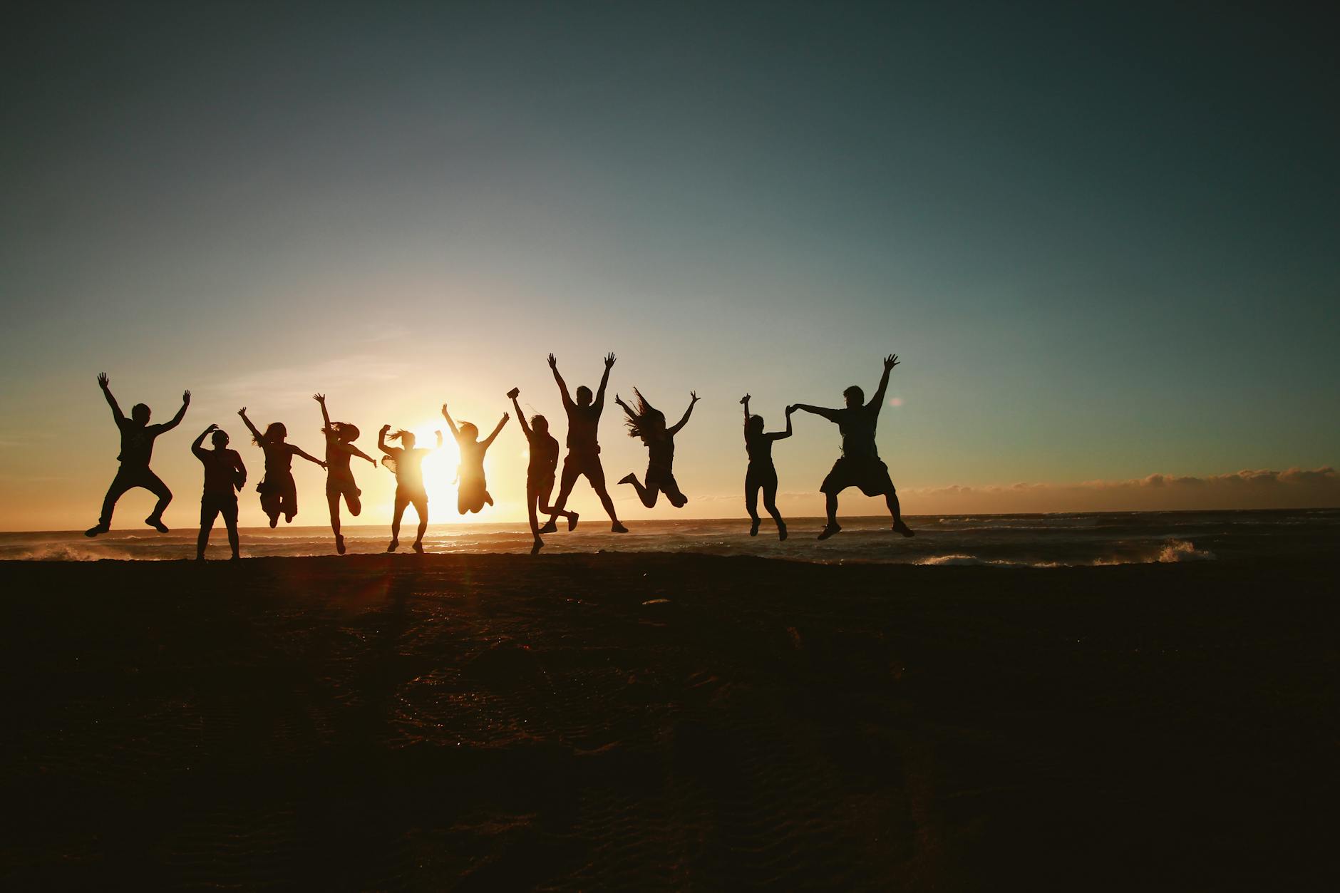 Happy family jumping at beach